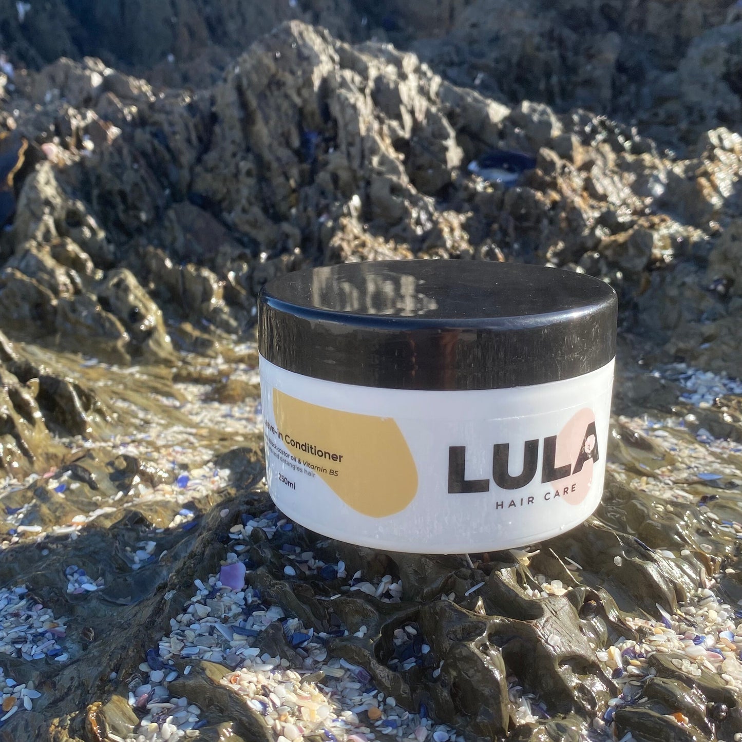 LULA leave-in conditioner in a tub with beach background